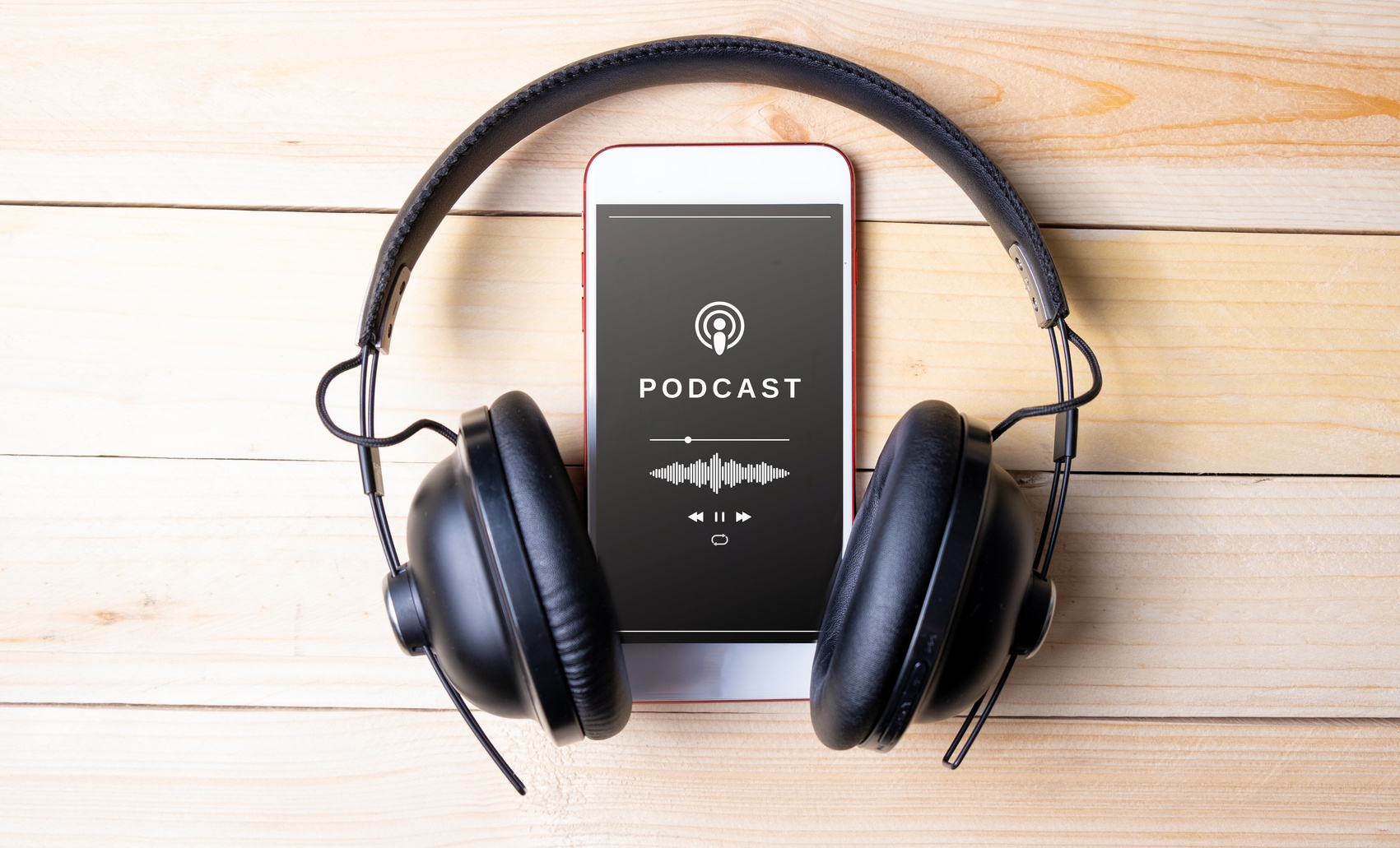 Phone Playing a Podcast with Headphones on Wood Background